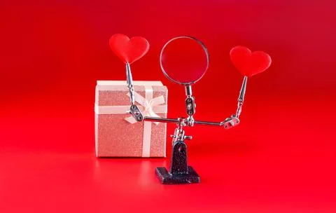 Valentines Day background with tool third hand holding hearts and gift on red Foto stock