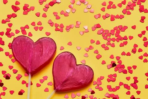 Valentines Day background. Two candy hearts with glitter on yellow backdrop. Top Stock Photos