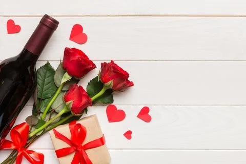 Valentine's day composition with red wine, rose flower and gift box on tabl.. Stock Photos