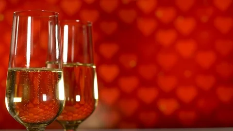 Valentines day concept. Two glasses with champagne at red with hearts background Video stock 110923993