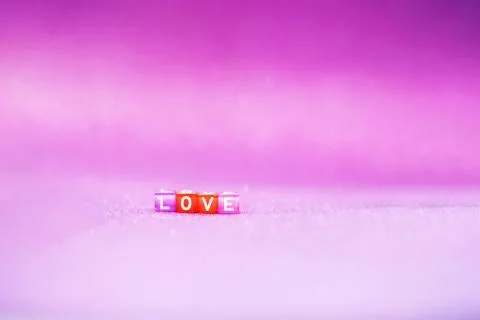 Valentine's day creative card on a lilac background with inscription love. Stock Photos