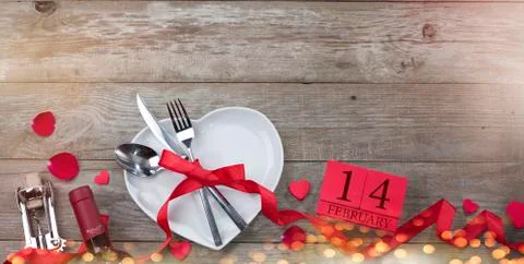 Valentine's day dinner concept. Fork, spoon and knife in heart plate on old t Stock Photos