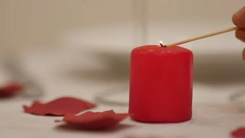 Valentine's day dinner table: man waiter or lover lighting up a red love candle Stock Footage 146226293