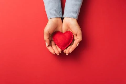 Valentines Day love expression concept with red heart on woman palms Stock Photos