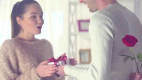 Valentine's Day scene. Happy young man giving a gift to his girlfriend. Love Stock Footage