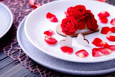 Valentine's Day Serving. Beautiful table setting with scarlet roses Stock Photos