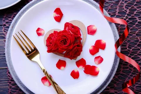 Valentine's Day Serving. Beautiful table setting with scarlet roses Stock Photos