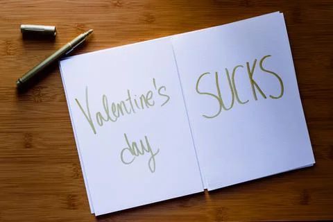 Valentine's day sucks written on some paper with the marker aside Stock Photos