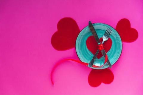 Valentine's day table setting with blue plate, fork, knife, loop and hearts.  Foto stock