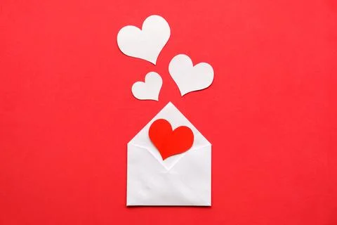 Valentines day theme. White envelope with a red heart inside, white hearts on Stock Photos