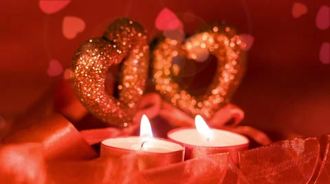 Valentines day,  two candles burning in front of falling hearts, closeup Stock Footage 45658259