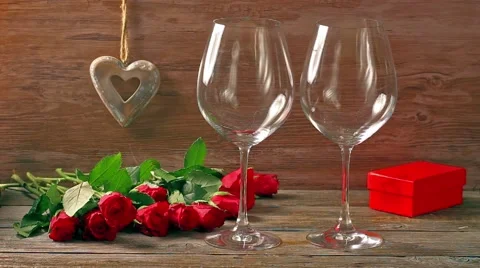 Valentines day's arrangements with red roses and two wine glasses over gray Stock Footage 59163533