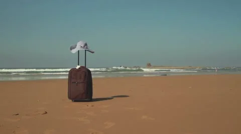 Valise with summer hat on the beach Stockbeeldmateriaal 10892272