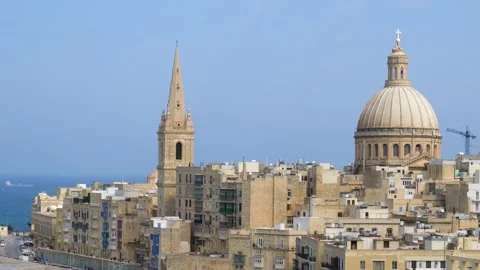 Valletta rooftops cluster beneath the carmelite dome and cathedral spire Stock Footage 341805045