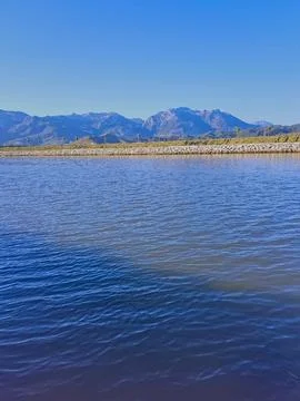 Valley flows gently, framed by distant mountain range &amp; artfully arranged rocks Stock Photos