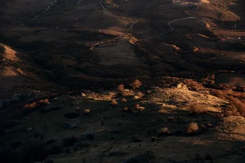 The valley in the mountains is bathed in the last rays of the setting sun. Stock Photos