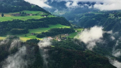 Valley-side hamlets and pasture parcels bordered by trees, aerial view Stock Footage 321367936