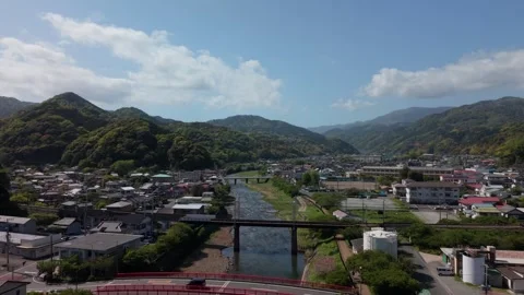 Valley town split by a river running past a low railway bridge, Kawazu, Izu Stock Footage 345184517