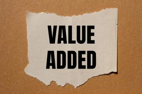 Value added message written on ripped torn paper piece with brown backgroun.. 写真素材