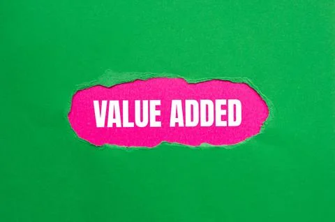 Value added message written on ripped torn green paper with pink background.. Stock Photos