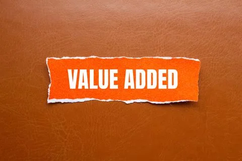 Value added message written on ripped orange torn paper piece with brown ba.. Stock Photos
