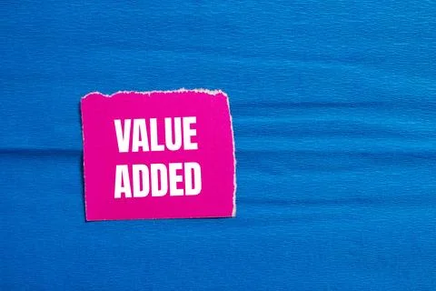 Value added message written on ripped pink torn paper piece with blue backg.. Stock Photos