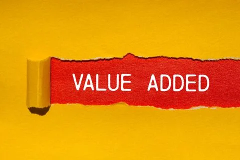 Value added message written on ripped torn yellow paper with red background.. Stock Photos