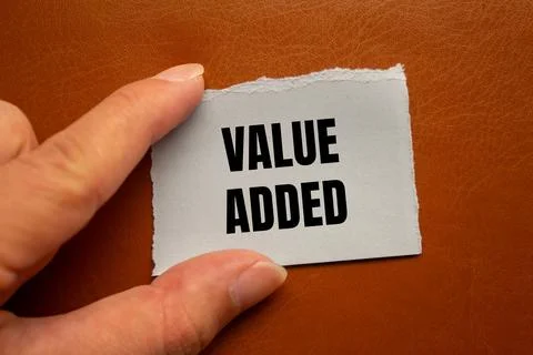 Value added message written on ripped torn paper piece with brown backgroun.. 스톡 사진