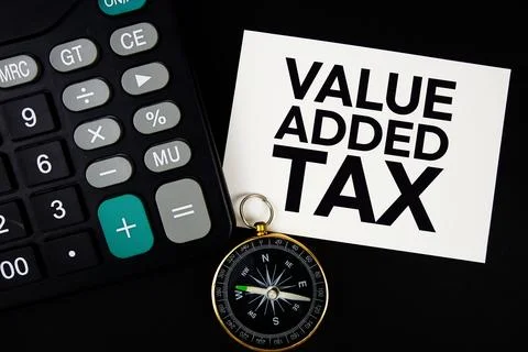 Value Added Tax text with compass and calculator on black background Foto stock