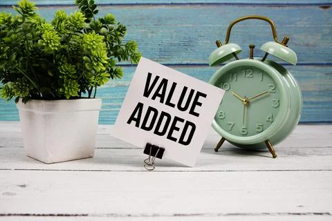 Value Added text written on paper card with alarm clock on wooden background 스톡 사진