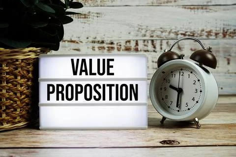 Value Proposition text on light box with alarm clock on wooden background Stock Photos