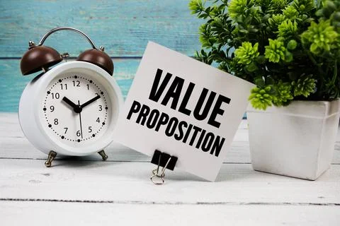 Value Proposition text written on paper card with alarm clock on wooden bac.. Stock Photos