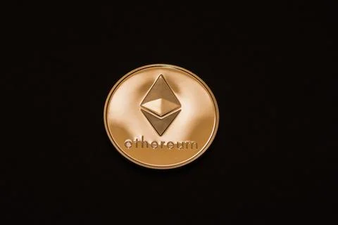 Valueable shining gold ether coin from cryptocurrency middle on black Foto stock