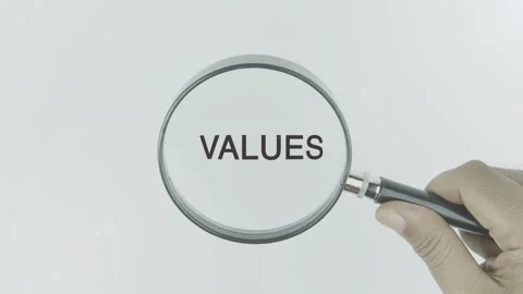 Values text or word highlighted by a magnifying glass in a hand on a white Stock Footage 303731341