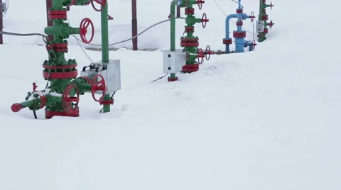 The valves at the wellhead production. In the background processing plant gas Stock Footage 57759774