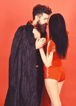 Vampire in cloak and sexy devil girl holds hands. Couple in love, perfect match 스톡 사진