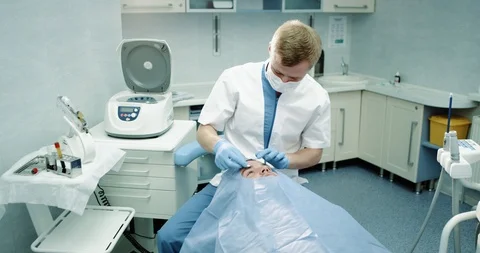 Vampire facelift procedure in a modern clinic doctor starting the procedure for Stock Footage 100436767