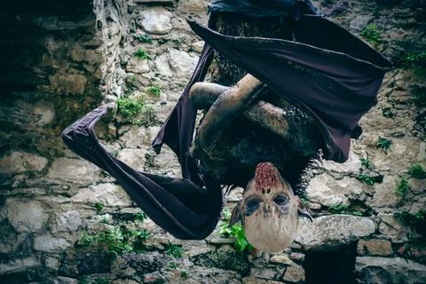 Vampire hanging upside down between castle walls. Halloween costume. Stock Photos