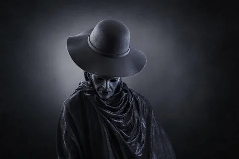 Vampire with old hat over dark misty background Stock Photos