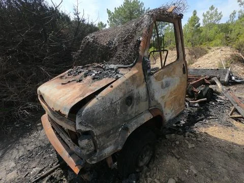 Van completely destroyed by fire and abandoned total wreck on a plot of land. Stock Photos