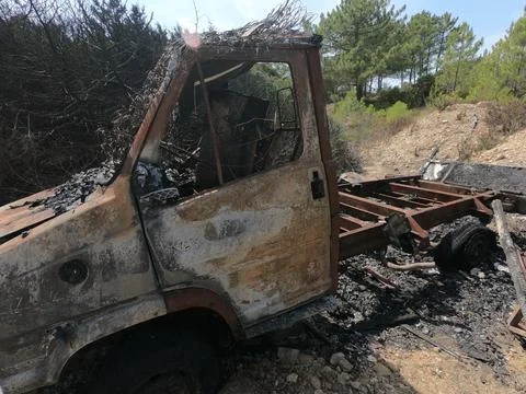 Van completely destroyed by fire on a plot of land Stock Photos