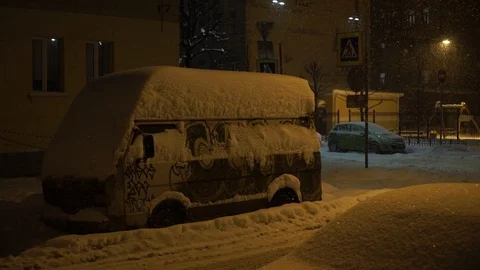 Van is covered with snow. Heavy snowfall in the city at night. Stock Footage 89181599