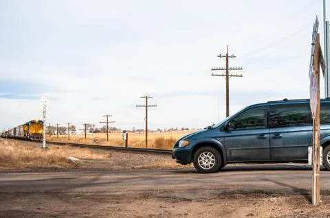A van crossing the tracks in front of a train Foto stock
