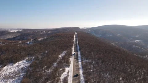 Van drive in snow winter day on the road mountain range aerial view Stock Footage 261171829