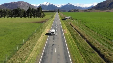 Van drives into frame on Scenic Straight Highway within Mountain Range Stock Footage 130358328