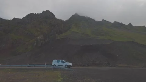 Van Driving Along Remote Road Beneath Rugged Mountains in Öxarfjörður North Stock Footage 346605624