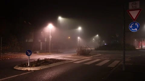 Van driving in and out of a roundabout during a dark misty night 스톡 동영상 166856267