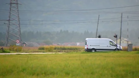 Van driving on countryside road next to railroad Stock Footage 169916759