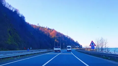 A van driving down a road next to a body of water Video stock 273013357