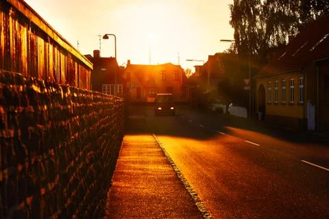 A van driving through town at sunset Stock Photos